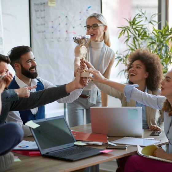 Employees celebrating a team win performance management
